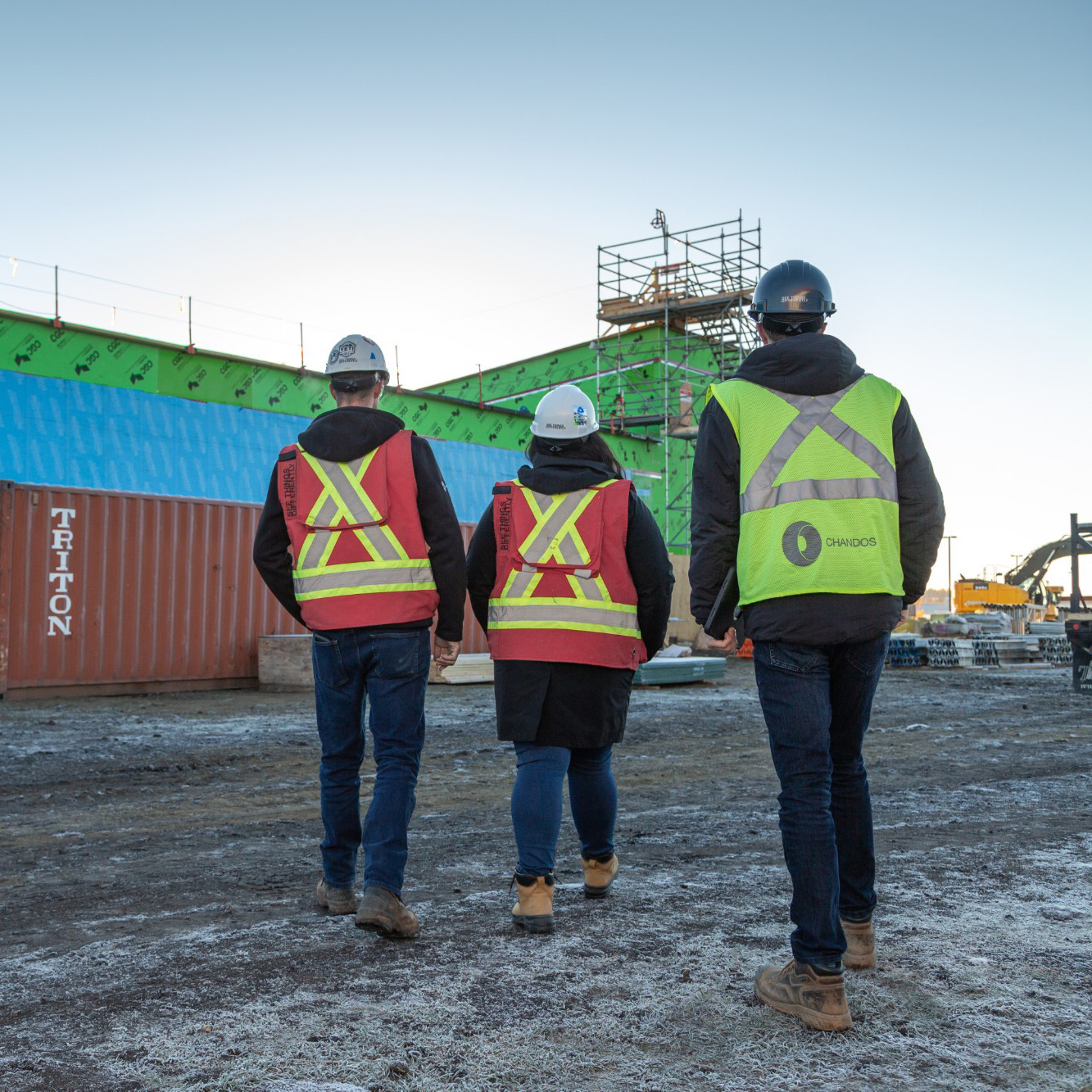 Three Chandos construction workers walking together towards a construction site.