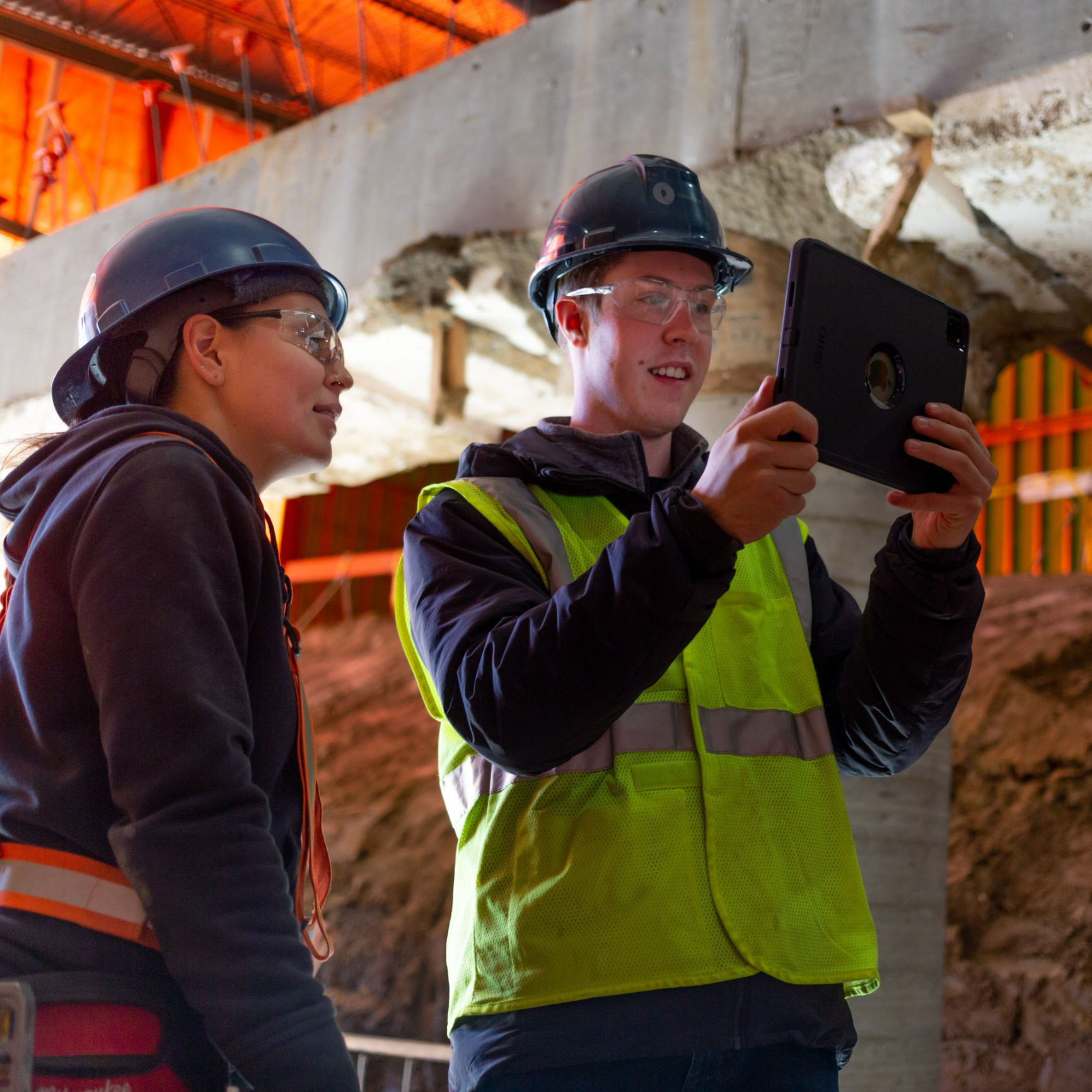 Two Chandos construction workers using technology to view and discuss a project on site.