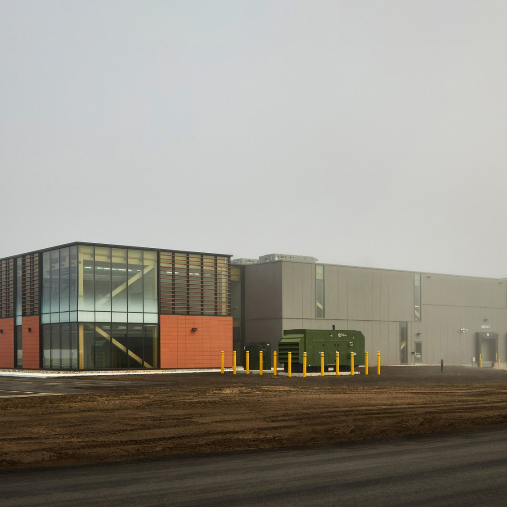 A rendering of the Advanced Nuclear Materials Research Center building at night time.