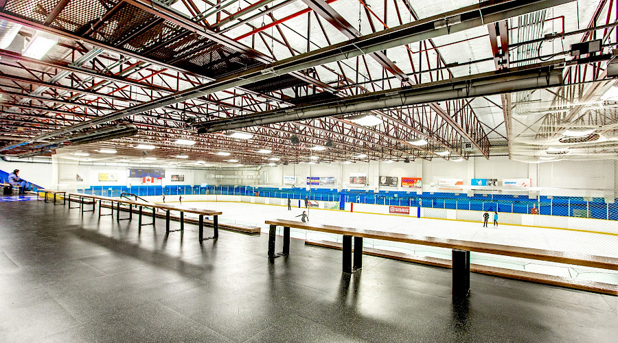 Benches in the stands overlooking a hockey rink.