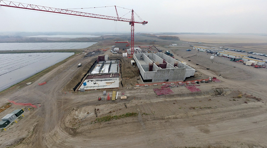 An aerial photo of a large red crane at the Lloydminster Wastewater Treatment Facility construction site.