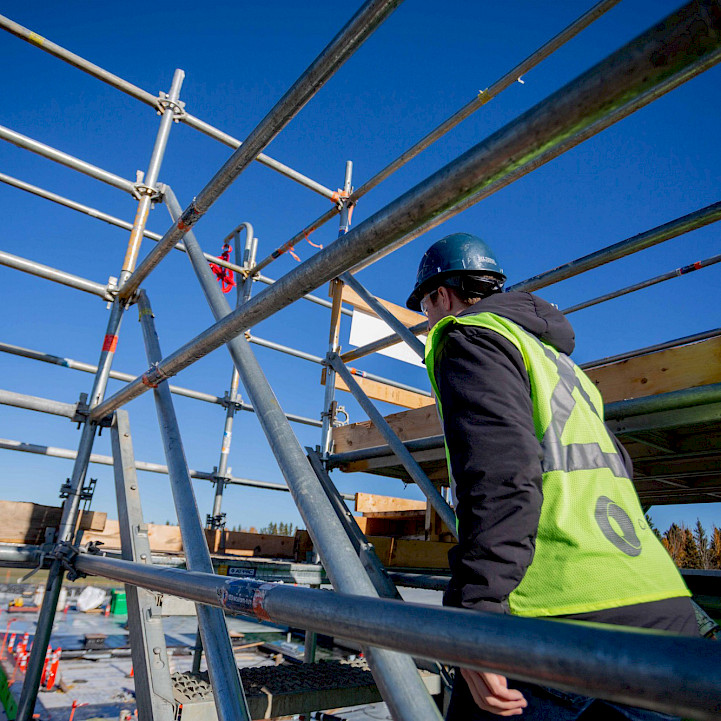 Chandos construction employee walking stairs at a construction site.