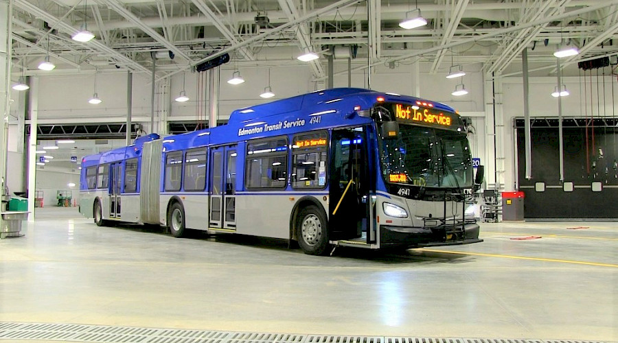 A city bus inside a maintenance garage.