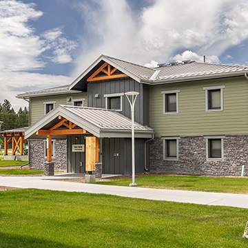 A photo of the green and grey stone building that is student housing at the College of the Rockies in Cranbrook, British Columbia.