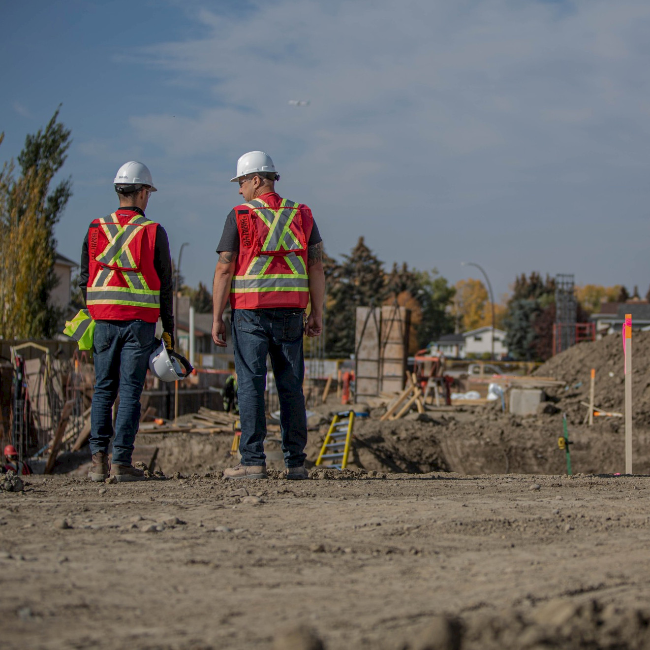 Two construction workers overlooking a site from far away.