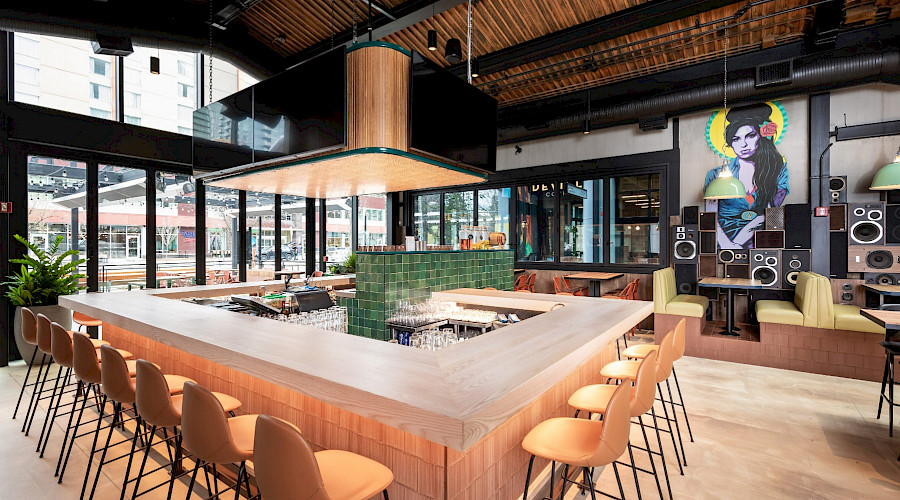 A long square bar top in a restaurant room with large windows and wood ceilings at The Central Taps and 33 Acres restaurant and 33 Acres Brewing bar in downtown Calgary