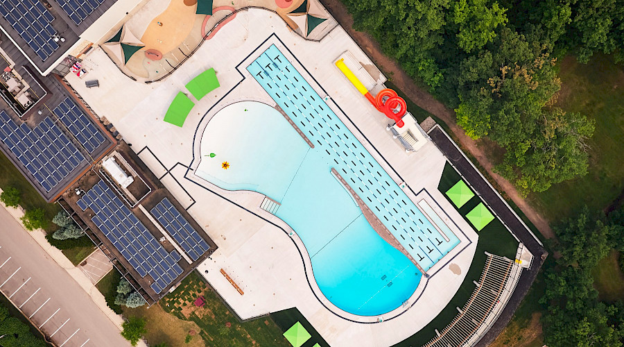 Aerial image of the Burlington Mountainside Pool, deep end and wading shallow end, with barrier free access, self-performed concrete fencing and shade structure.
