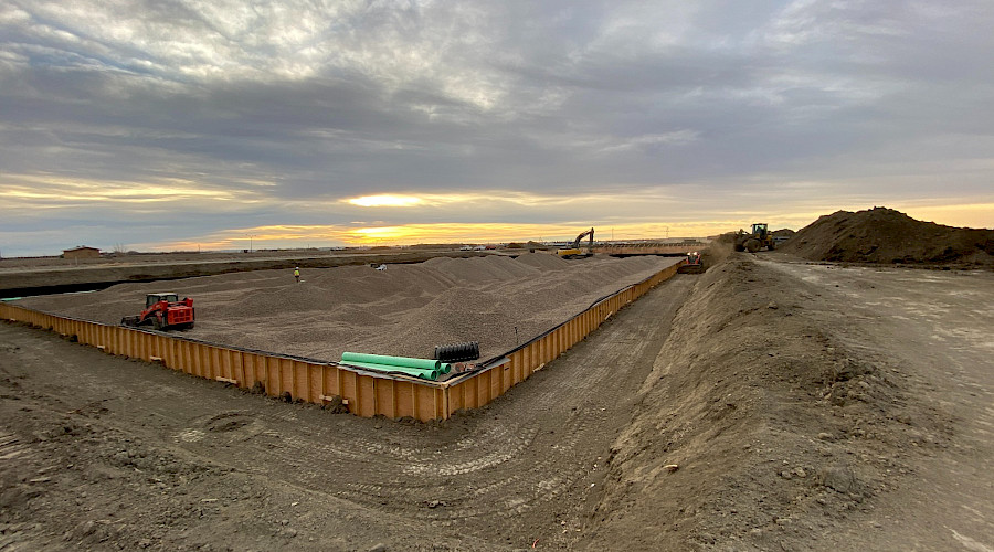 A wide angle shot of the Coaldale Wastewater Treatment Facility under construction at sunset.