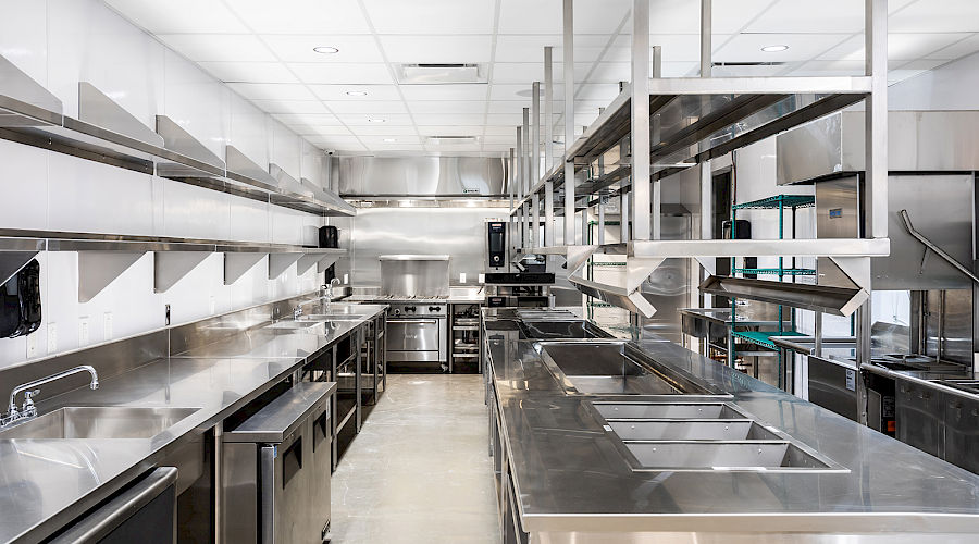 Interior image of the Seed n Salt kitchen with industrial appliances and shelving installed by Chandos Construction in Calgary, AB.
