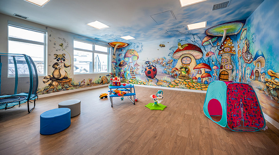 Image of a playroom in the Child and Family Centre built by Chandos Construction in Calgary, Alberta. The room is decorated with fun cartoons and toys.
