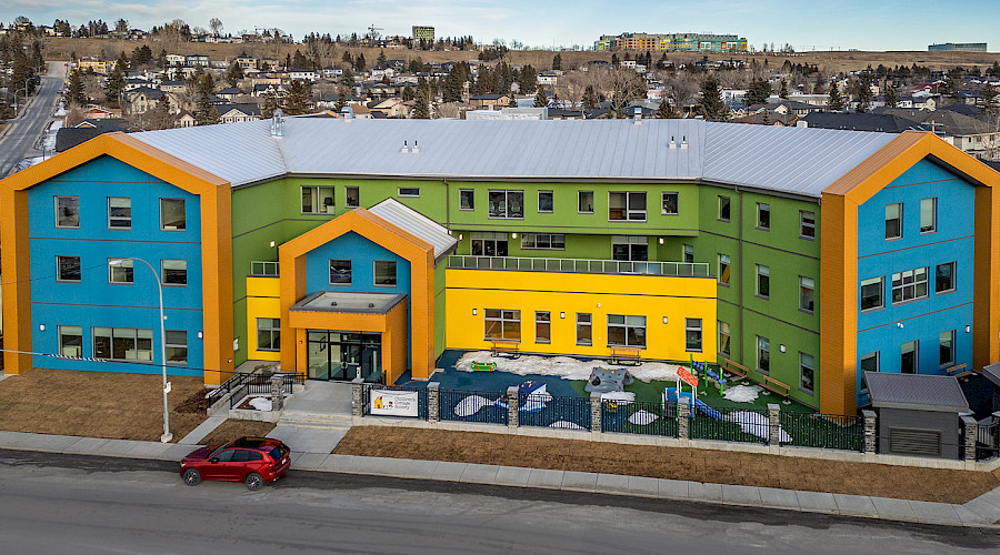Exterior shot of the Child and Family Centre built by the Chandos Construciton team in Calgary, Alberta. The building is colorful with vivid blues, oranges, yellows, and greens.