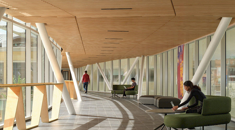 Interior image of the pedestrian bridge at the Aurora Town Square centre, built by Chandos Construction Toronto. The contained bridge features natural wood ceilings and floor to ceiling windows.