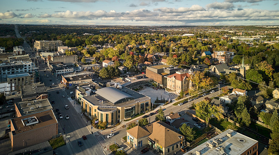 Drone image of Aurora Town Square built by Chandos Construction Toronto. Image contains view of the new building, pedestrian bridge, and surrounding neighbourhood.